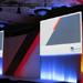 AXA Wealth branded podium with two large projector screens, custom backdrop and central podium